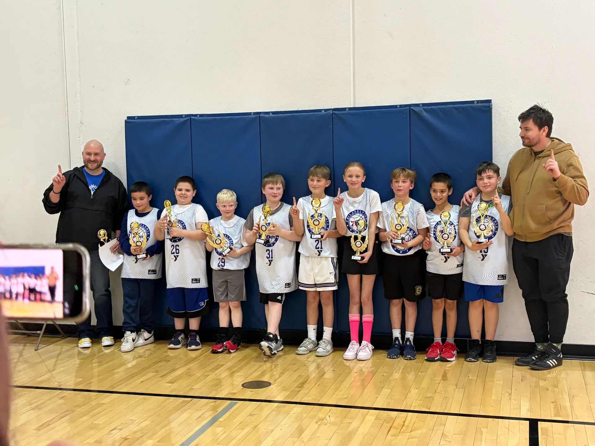 YMCA basketball team with trophies, 2026